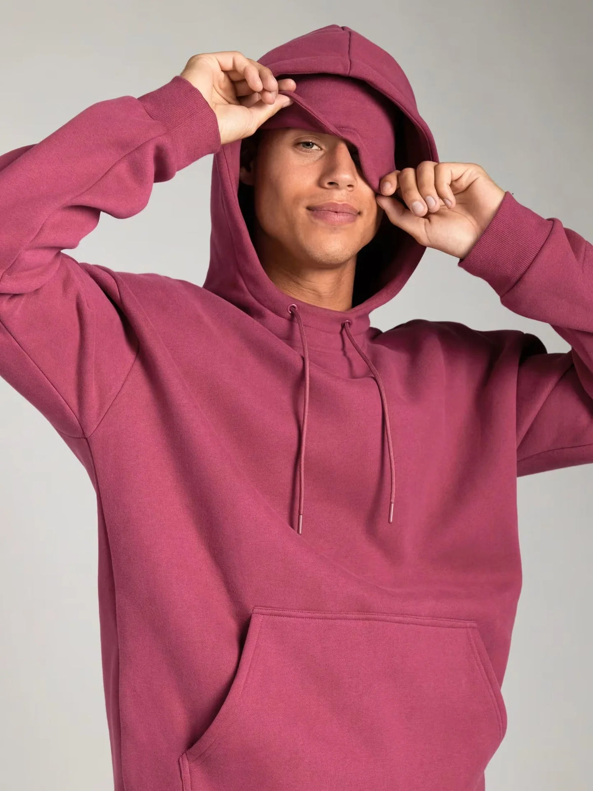 Person wearing a maroon hoodie against a plain background