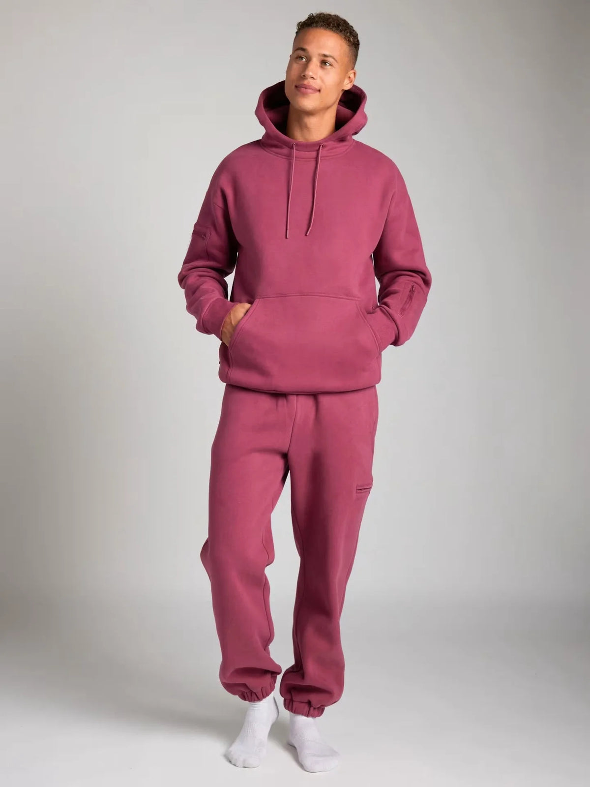 Person wearing a pink tracksuit against a plain background