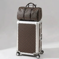 The Monarch premium aluminum luggage set in Heritage Bronze, featuring a zipperless interlocking frame, curated and certified by AERIA Prestige.