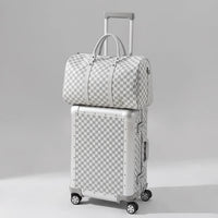 Checkered suitcase and duffel bag on a beige background