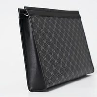 Black patterned clutch bag on a light gray background