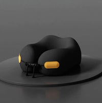 Black travel neck pillow with yellow accents on a dark gray background