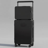 Black suitcase with a smaller black box on top, placed on a wooden floor.