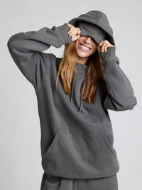 Person wearing a gray hoodie on a plain background