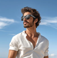 Man wearing sunglasses and a white shirt against a blue sky