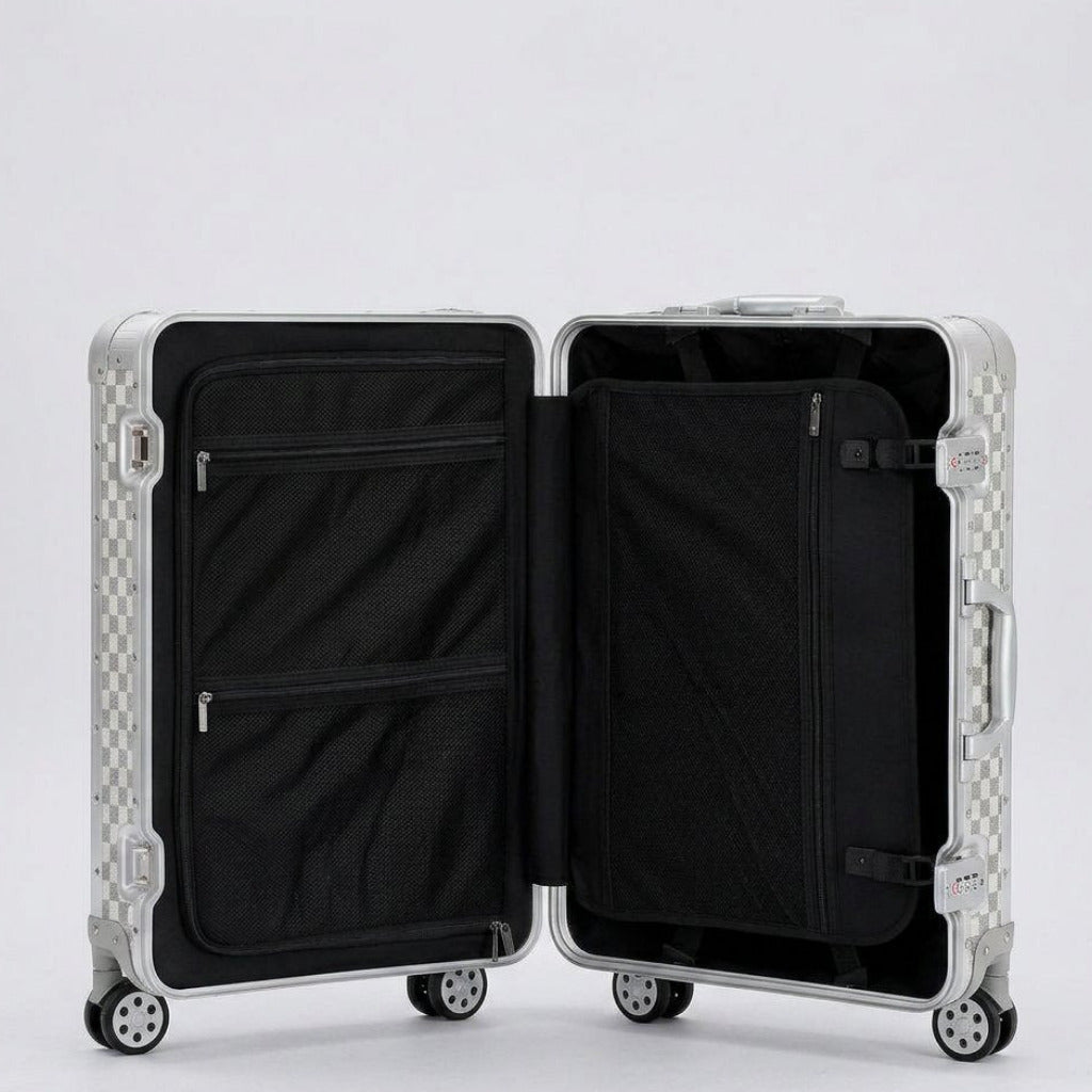 Interior view of Aeria Prestige The Monarch aluminum travel case in Alabaster White Damier finish, featuring dual packing compartments, zippered mesh divider pockets, and compression straps for organized travel.
