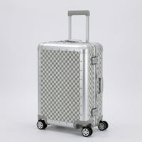 Aeria Prestige The Monarch aluminum travel case in Alabaster White Damier checkered finish, shown in a studio three-quarter view with extendable handle and smooth spinner wheels.
