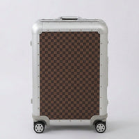 Front view of Aeria Prestige The Monarch aluminum travel case in Damier brown checkered design, highlighting the sleek metallic frame, protective corner caps, and smooth spinner wheels.