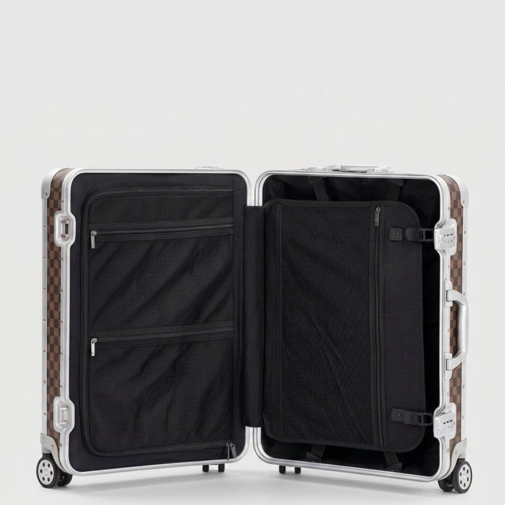 Interior view of Aeria Prestige The Monarch aluminum travel case in Damier brown, featuring dual packing compartments, zippered mesh divider pockets, and compression straps for organized travel.