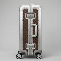 Side profile view of Aeria Prestige The Monarch aluminum travel case in Damier brown, highlighting the dual integrated TSA-approved combination locks, sturdy side handle, and reinforced frame.