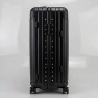 Side view of The Masterpiece Legacy aluminum luggage by AERIA PRESTIGE in Obsidian Black, featuring a durable zipperless aerospace-grade alloy frame and reinforced hinges.