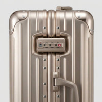 Close-up of the integrated dual TSA-approved combination locks on The Masterpiece Legacy aluminum luggage by AERIA PRESTIGE in Rose Champagne, showcasing bank-grade security and precision engineering.