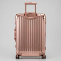 Rear view of The Masterpiece Legacy aluminum luggage by AERIA PRESTIGE in Rose Gold, showing the fully extended telescopic trolley handle, aerospace-grade alloy hardshell, and silent multi-directional spinner wheels.